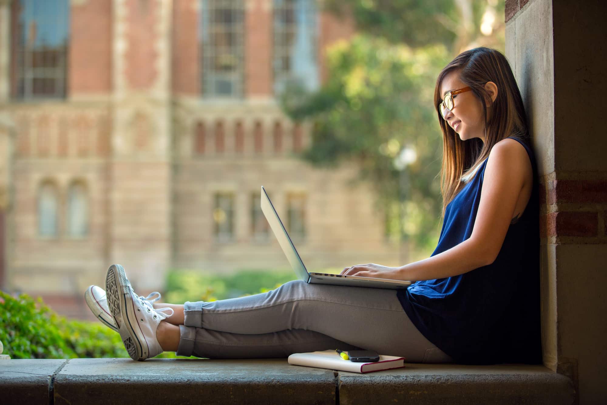 College student studying on campus outdoor with laptop casual lifestyle