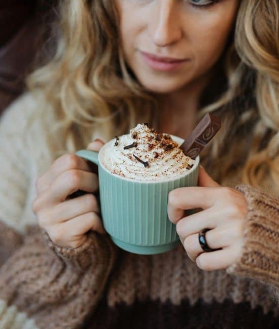 woman holding cup of hot cocoa