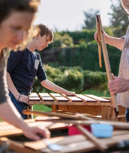 A,Family,Is,Building,Wooden,Containers,For,Their,Vegetable,Garden