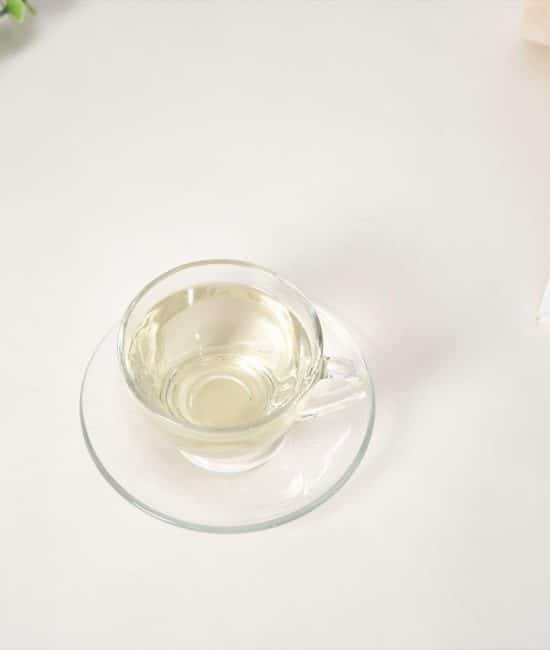 Pale yellow Abyssinian oil for skin in a small glass cup.