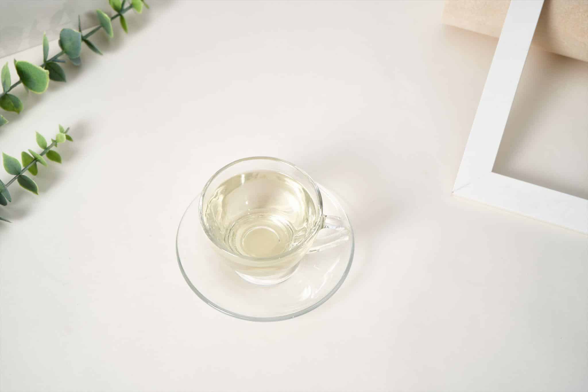 Pale yellow Abyssinian oil for skin in a small glass cup.