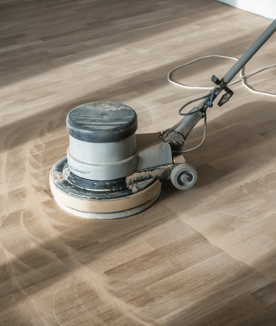 A floor sander cleaning the floor
