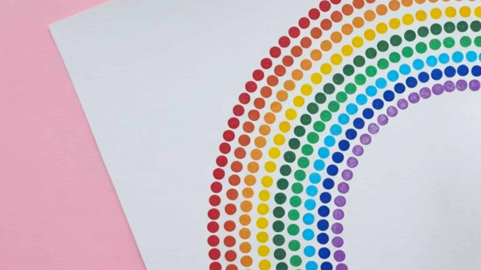 A delicate rainbow made entirely of tiny, colorful dots created with Q-tips on a clean white background.
