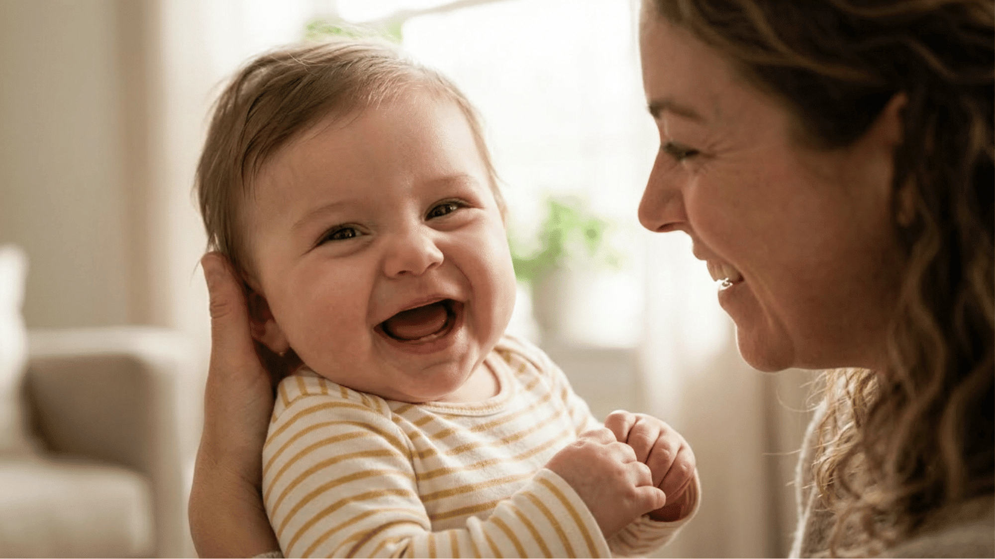 Baby showing early signs of laughter with smile and excited movement