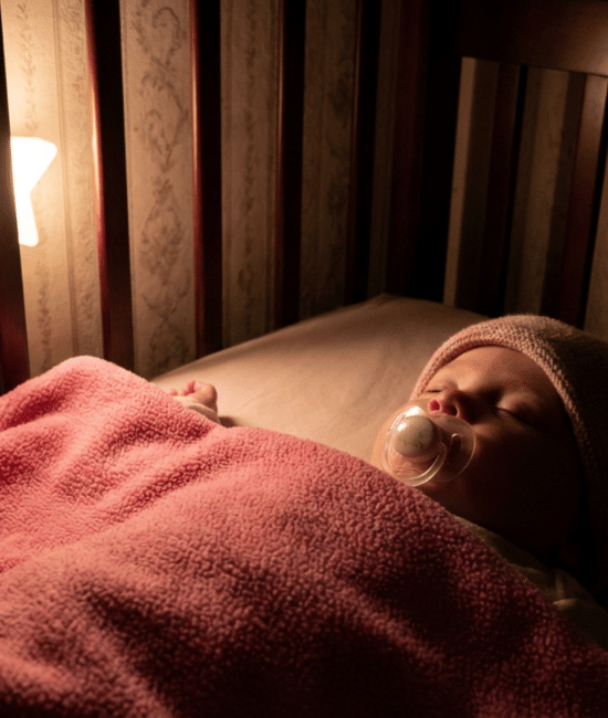 Blanket placed only on baby’s lower body in crib