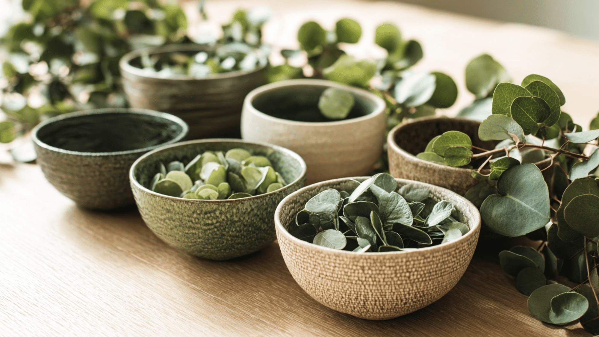 Ceramic pitchers with fresh flowers on table