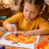 Child making a torn paper pumpkin mosaic craft, gluing orange and yellow tissue pieces onto a pumpkin outline at a fall-themed craft table.