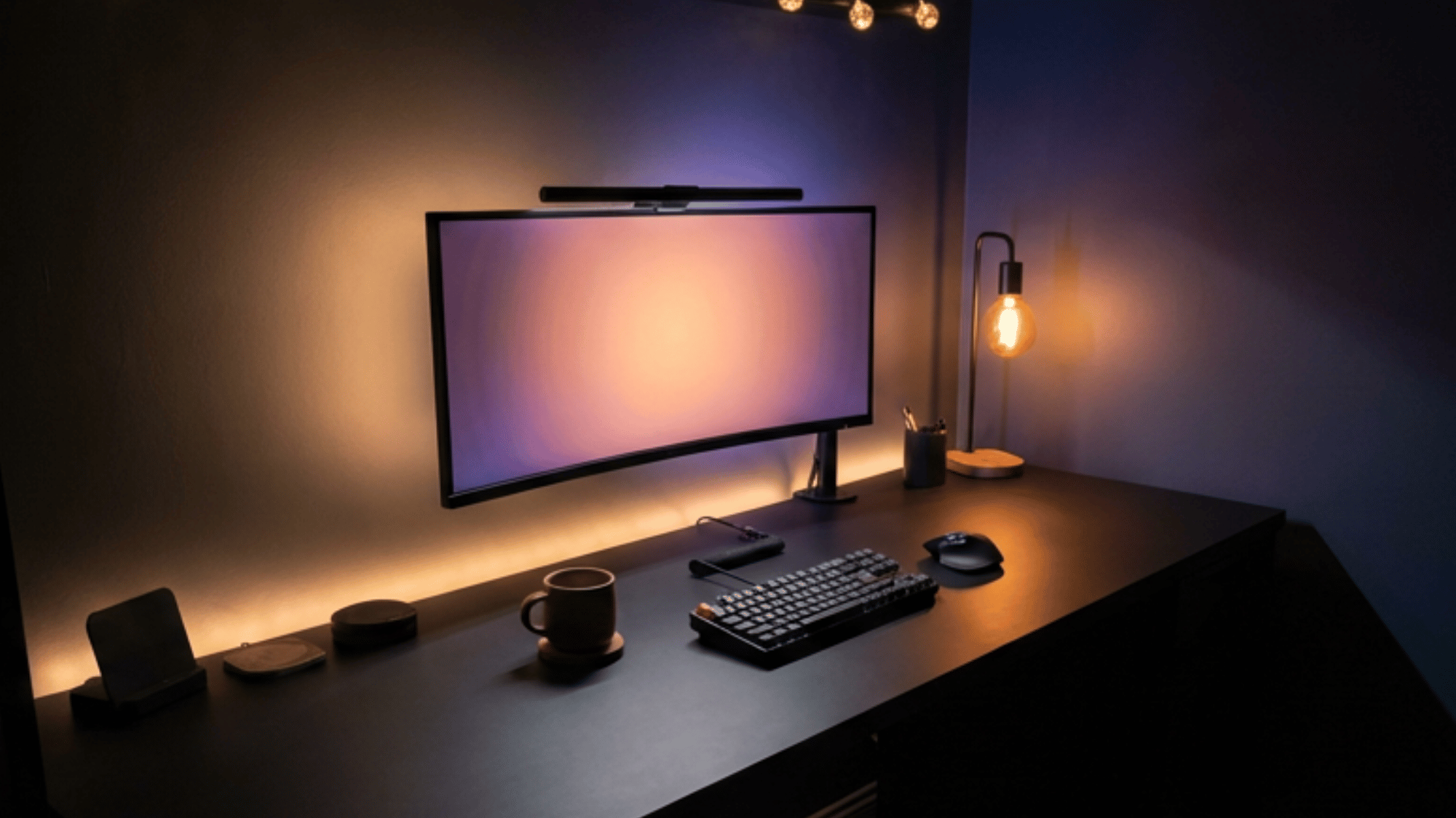 Dark home office setup with black desk and warm lighting