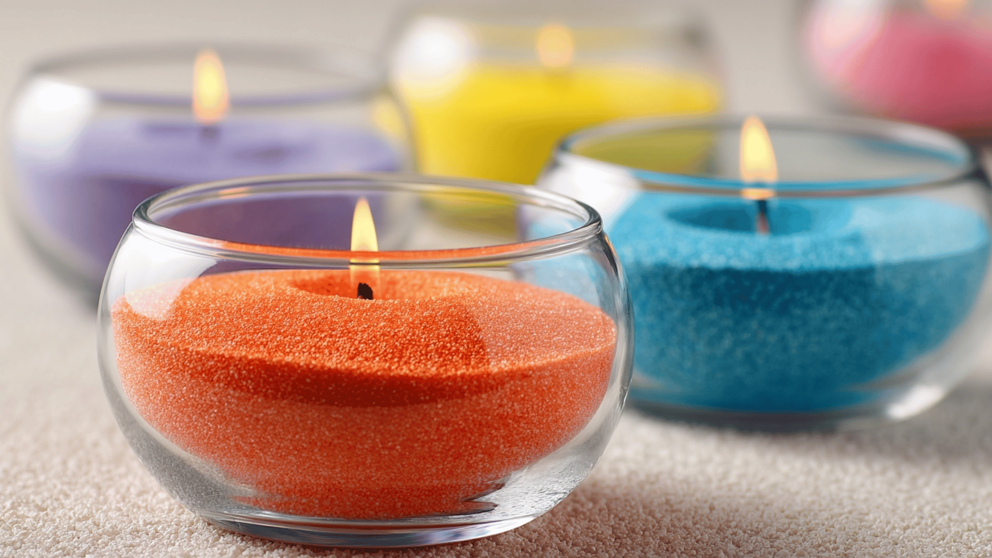 Glass bowls with colored sand and candles