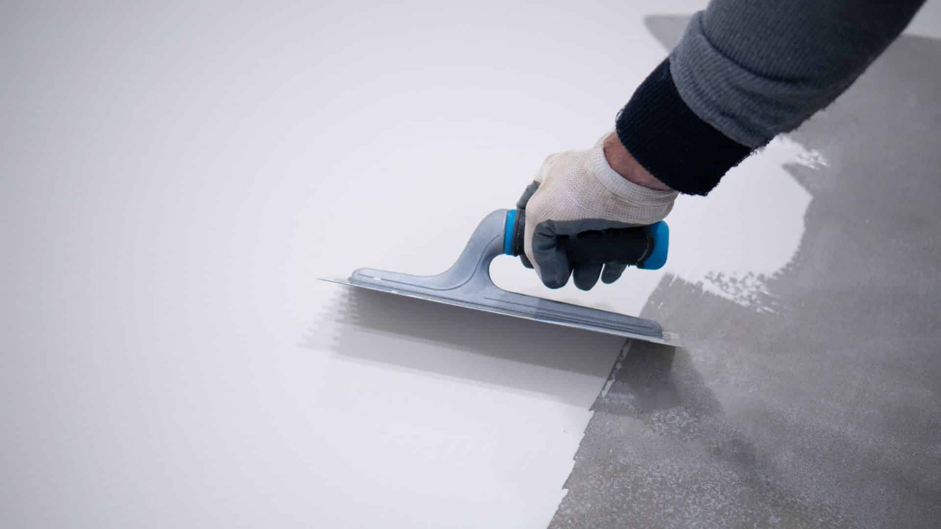 Hand sanding a glossy surface before painting, showing prep work needed for can you paint over polyurethane and ensure proper paint adhesion