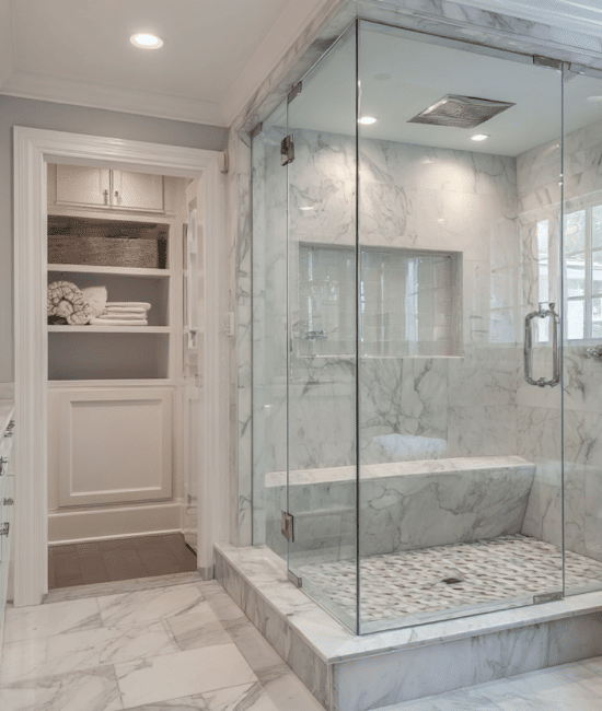 Luxurious primary bathroom featuring white marble vanity, a frameless glass shower enclosure with a built-in marble bench.
