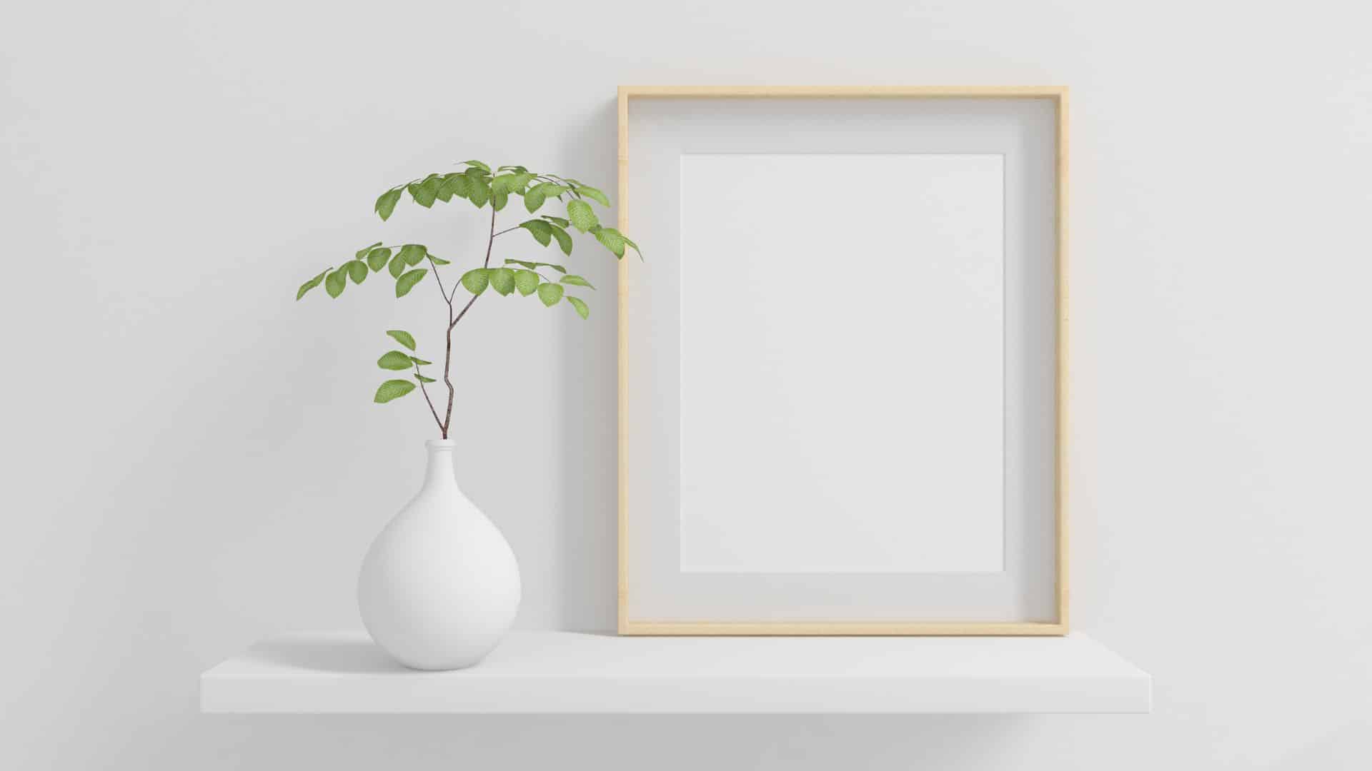 Minimalist diy canvas frame on shelf with light wood border and blank canvas, styled with plant decor showing clean modern framing idea