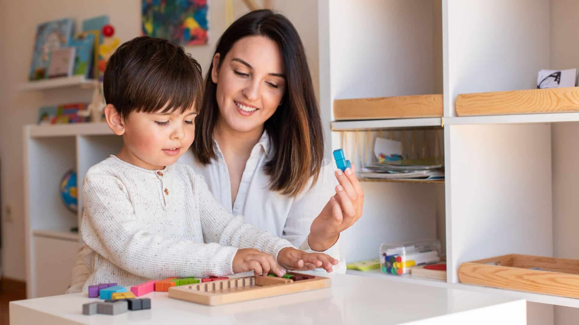 Mother helping child with hands-on learning activity using blocks at home, part of a kindergarten homeschool curriculum for early skills development