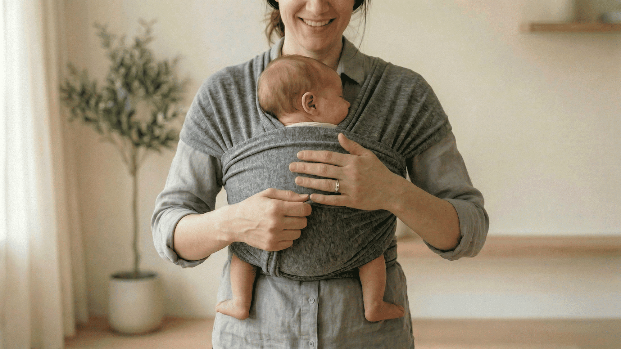 Newborn placed in baby wrap with fabric supporting knees and back