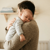 Parent gently burping baby to help relieve hiccups in a calm setting