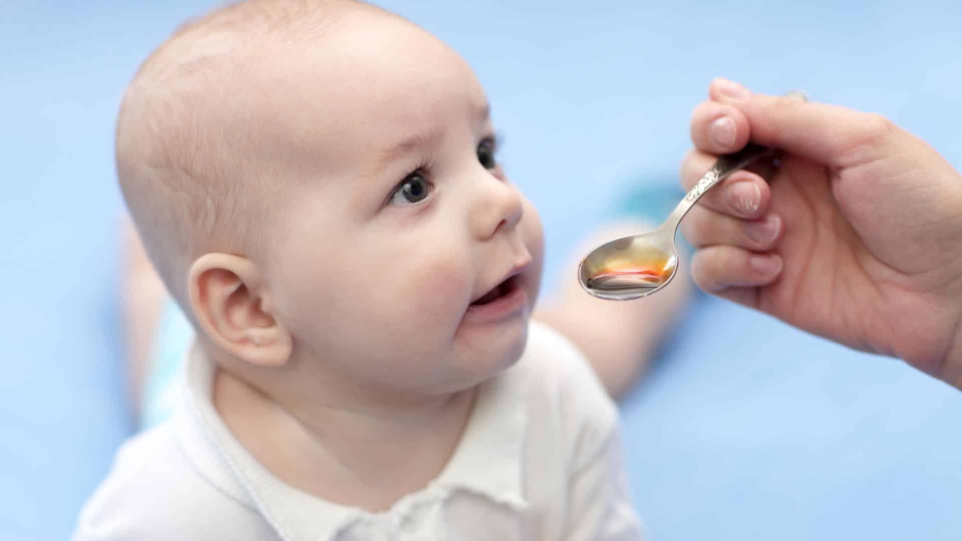 Parent giving toddler medicine with spoon, illustrating how to get toddler to take medicine calmly and safely