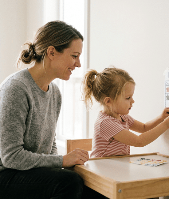 Parent helping child place a star on a simple reward chart for good behavior.