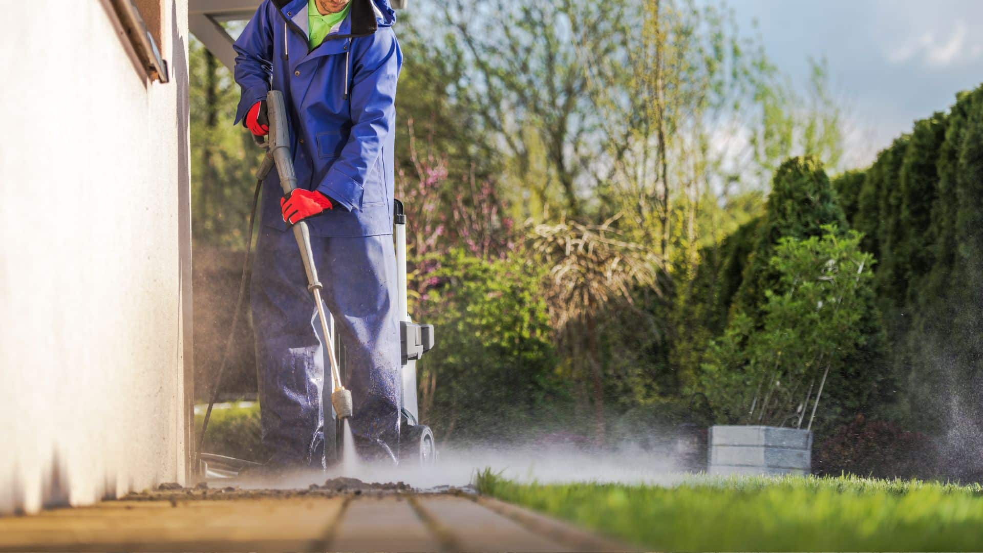 Pressure washing exterior wall to prep surface before applying lime washed brick finish, removing dirt, moss, and buildup for better adhesion