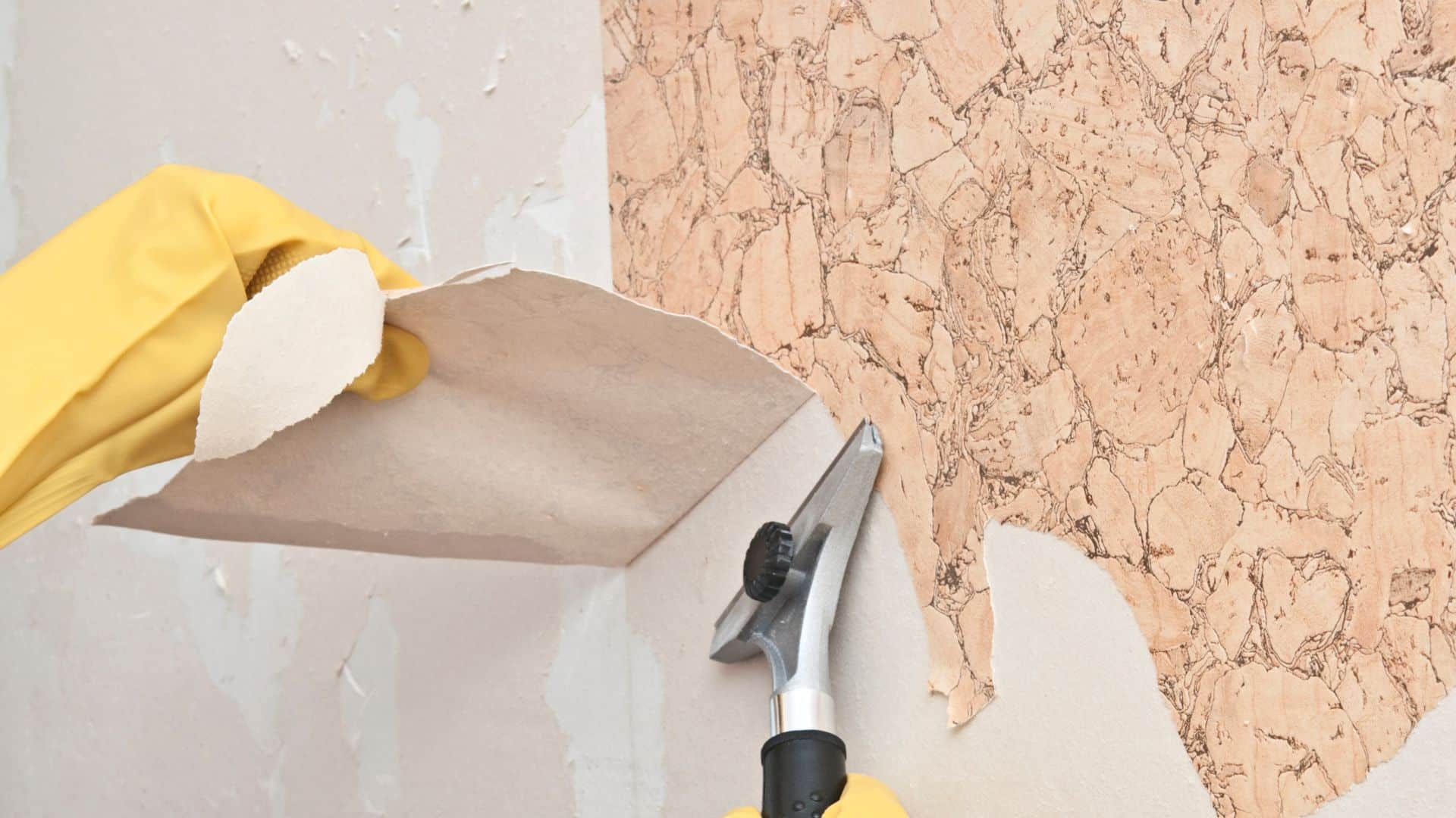 Removing old wallpaper with a scraper and sponge, showing step-by-step process for how to remove wall paper from walls cleanly and easily