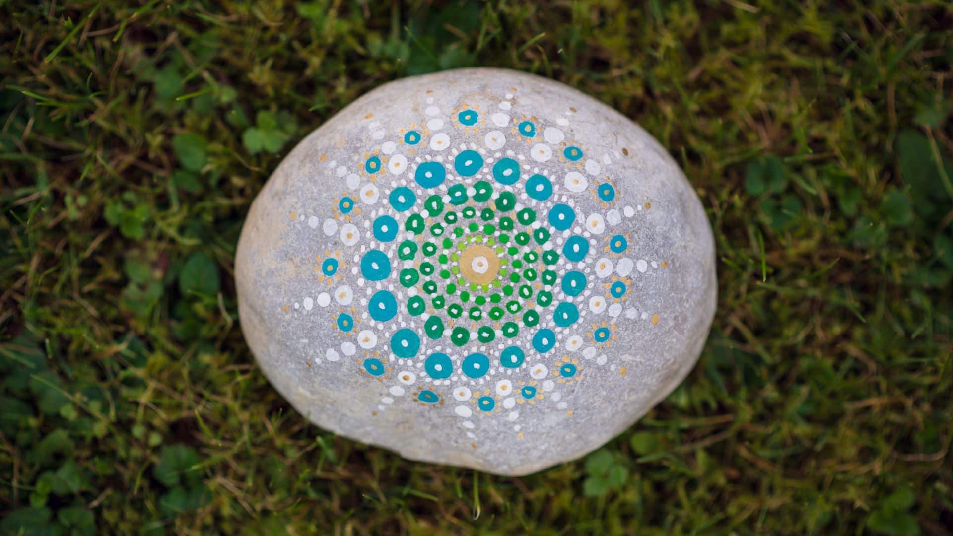 collection of smooth river stones painted to look like bright red ladybugs and smiling green monsters