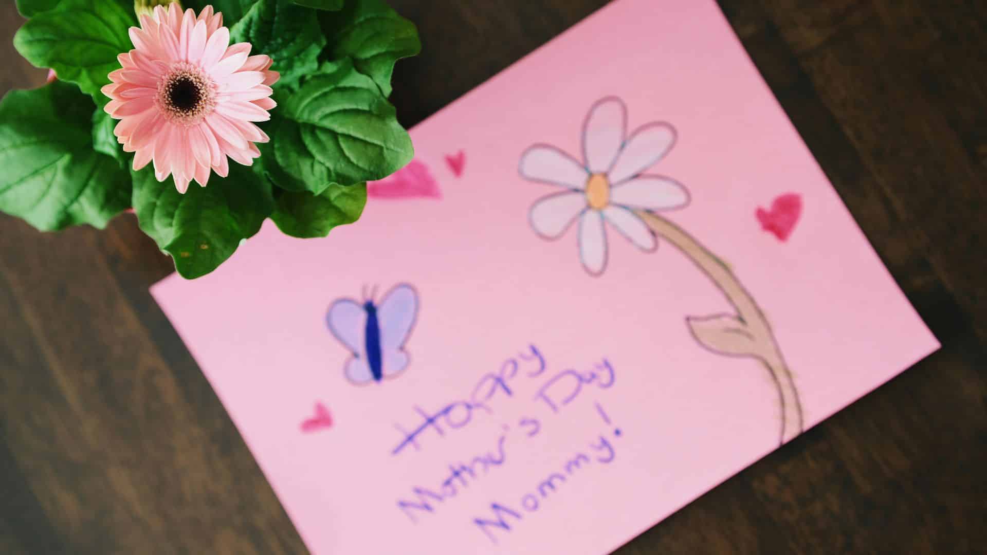 A Mother's Day card with a flower drawing, hearts, and 'Happy Mother's Day Mommy!' written on pink paper, perfect for a heartfelt message
