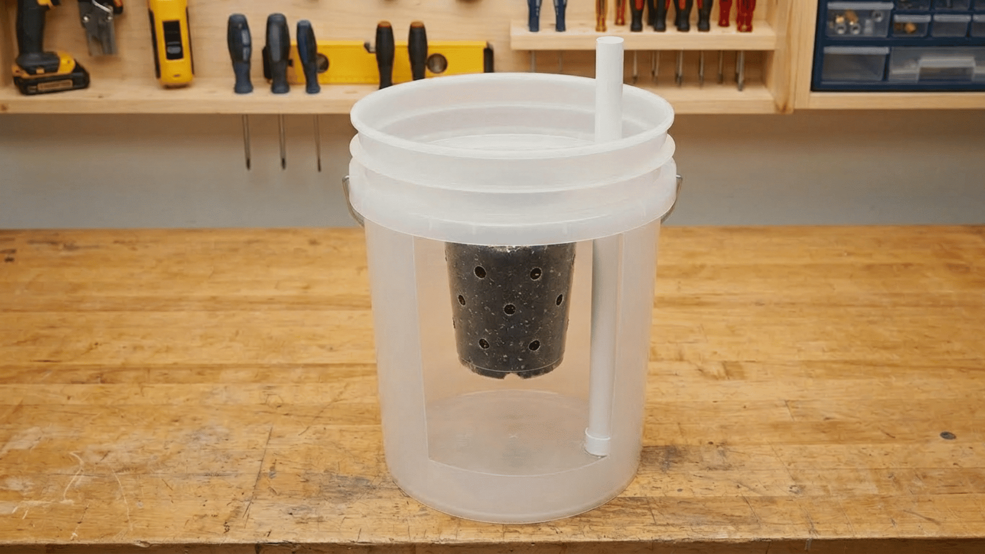 Assembling stacked buckets with wick chamber and pipe for self watering planter.