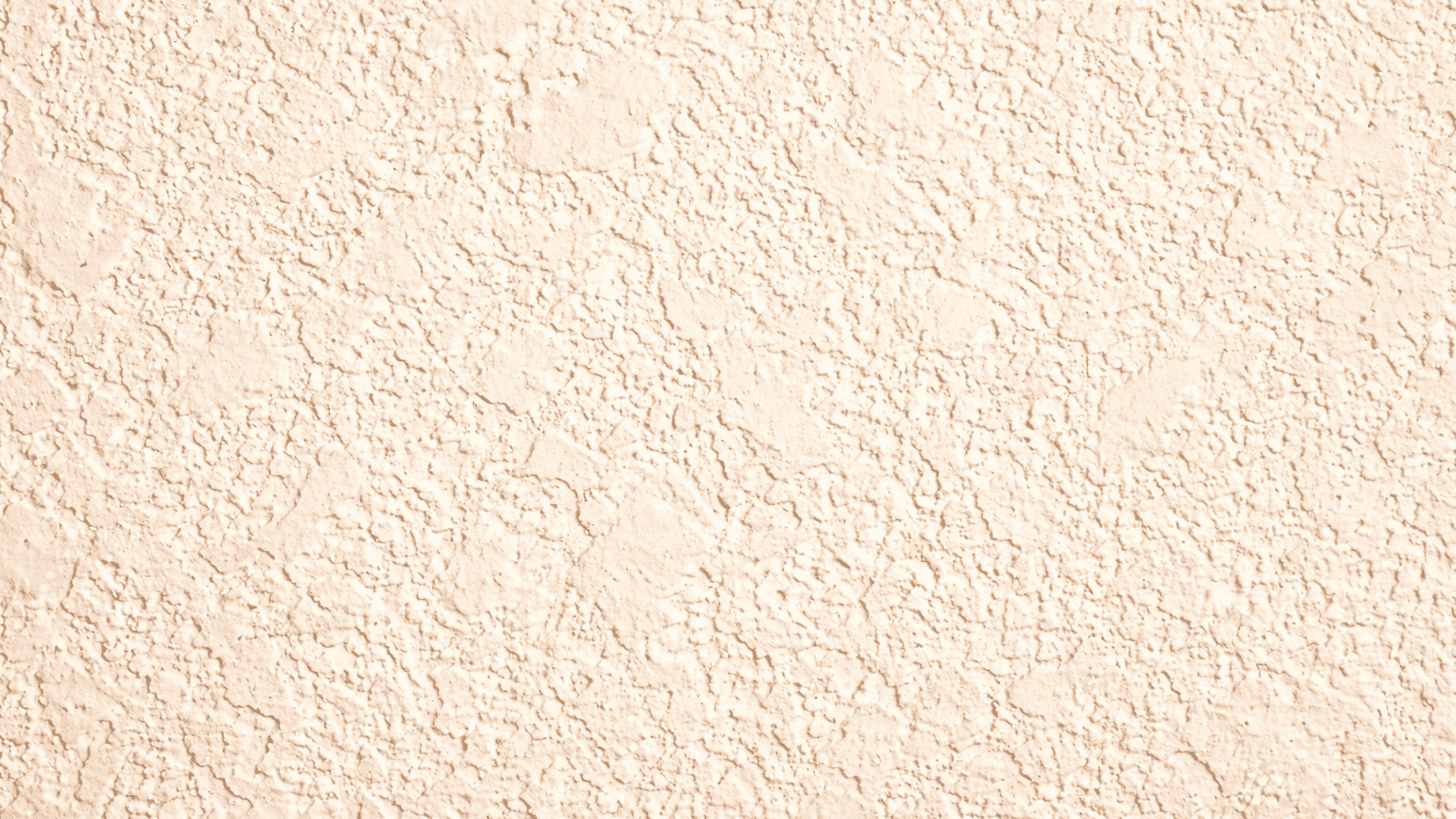 Close-up of beige knockdown drywall texture with flattened patches and splatter detail, matte finish, soft lighting depth