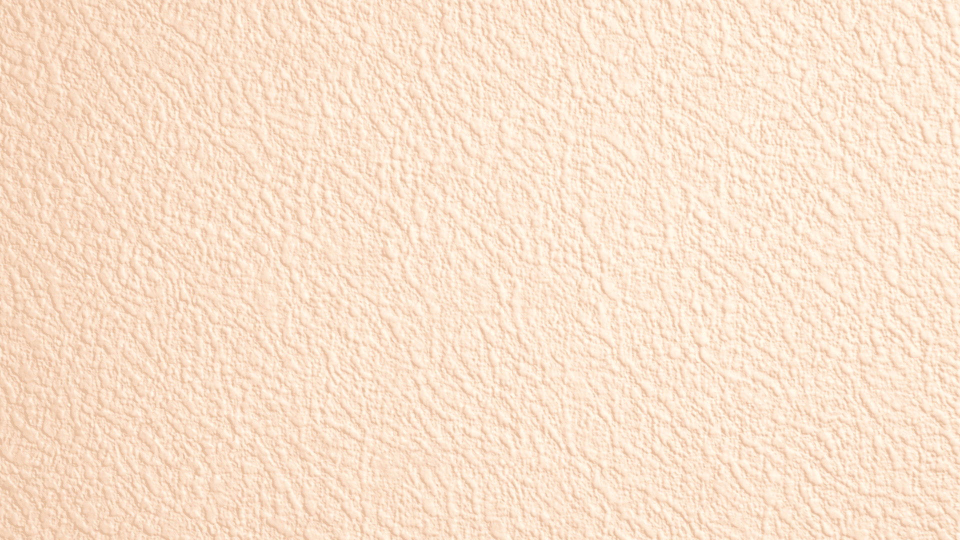 Close-up of beige orange peel drywall texture with fine uniform dimples, matte finish, and soft lighting highlighting surface detail