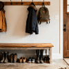 Cozy mudroom with wooden bench, coats and bags on hooks, shoes neatly arranged below, and muddy footprints on rug near entry door