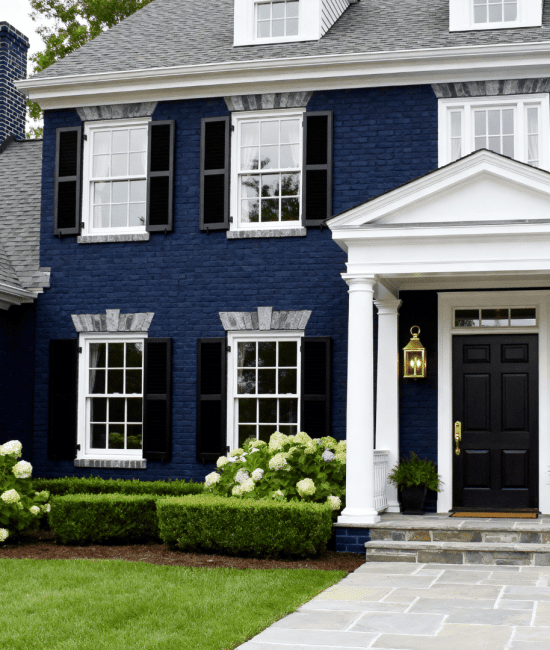 Full house exterior painted in deep navy blue brick with subtle gray undertones, creating a rich and timeless look. The entire home facade