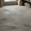 Small cracks on a concrete basement floor with storage items, showing a typical home setting