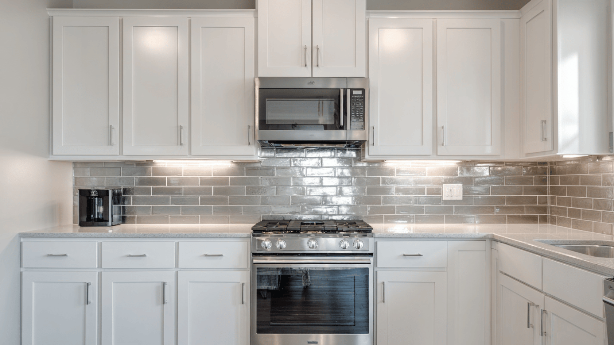 White kitchen with brushed metal tile backsplash and modern style
