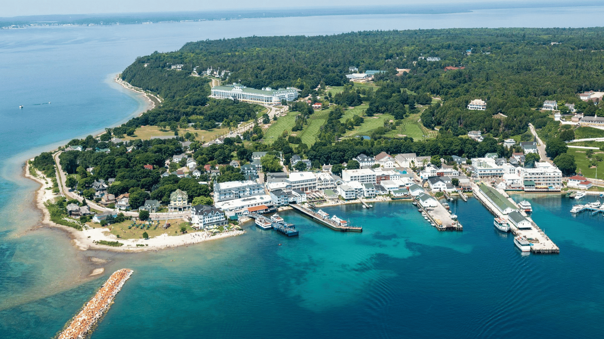 Aerial view of Mackinac Island Michigan harbor, turquoise water, docks and historic town