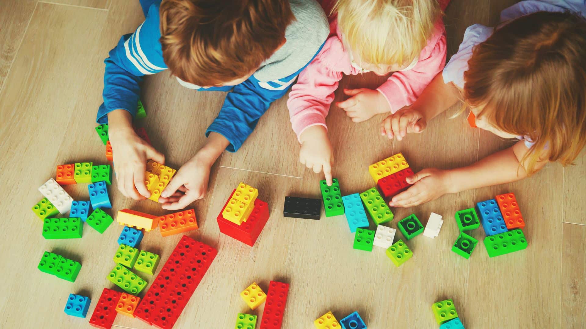 Children practicing life skills for kids by playing with colorful building blocks, promoting creativity, problem-solving, and teamwork