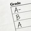 Close-up of report card showing handwritten grades like A and B under grade column.