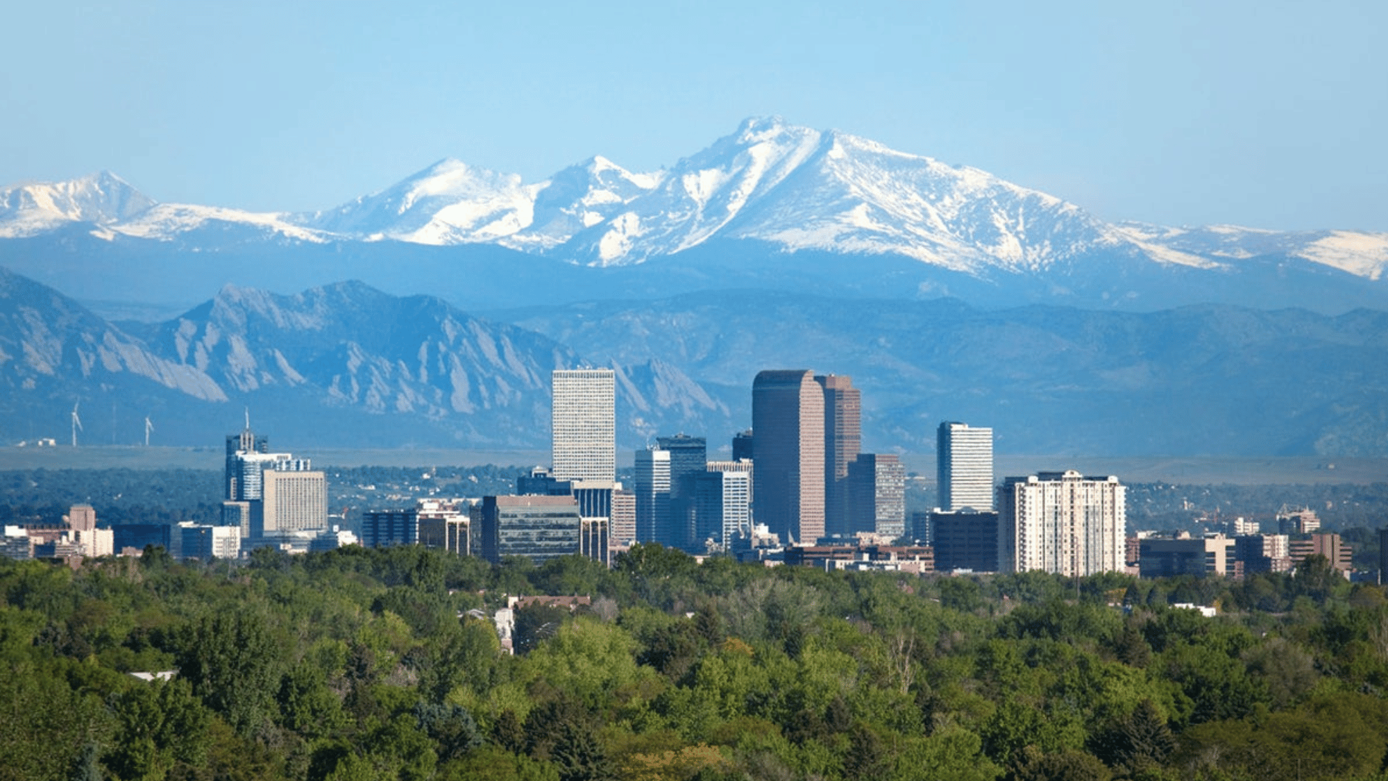 Denver Colorado skyline with downtown buildings and Rocky Mountains in the background