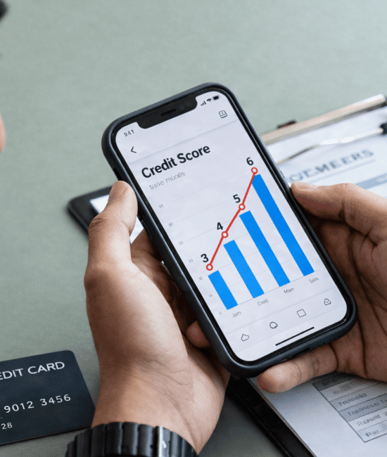 Two men reviewing a rising credit score on a phone, with a realistic credit card showing correct details like number and valid thru date