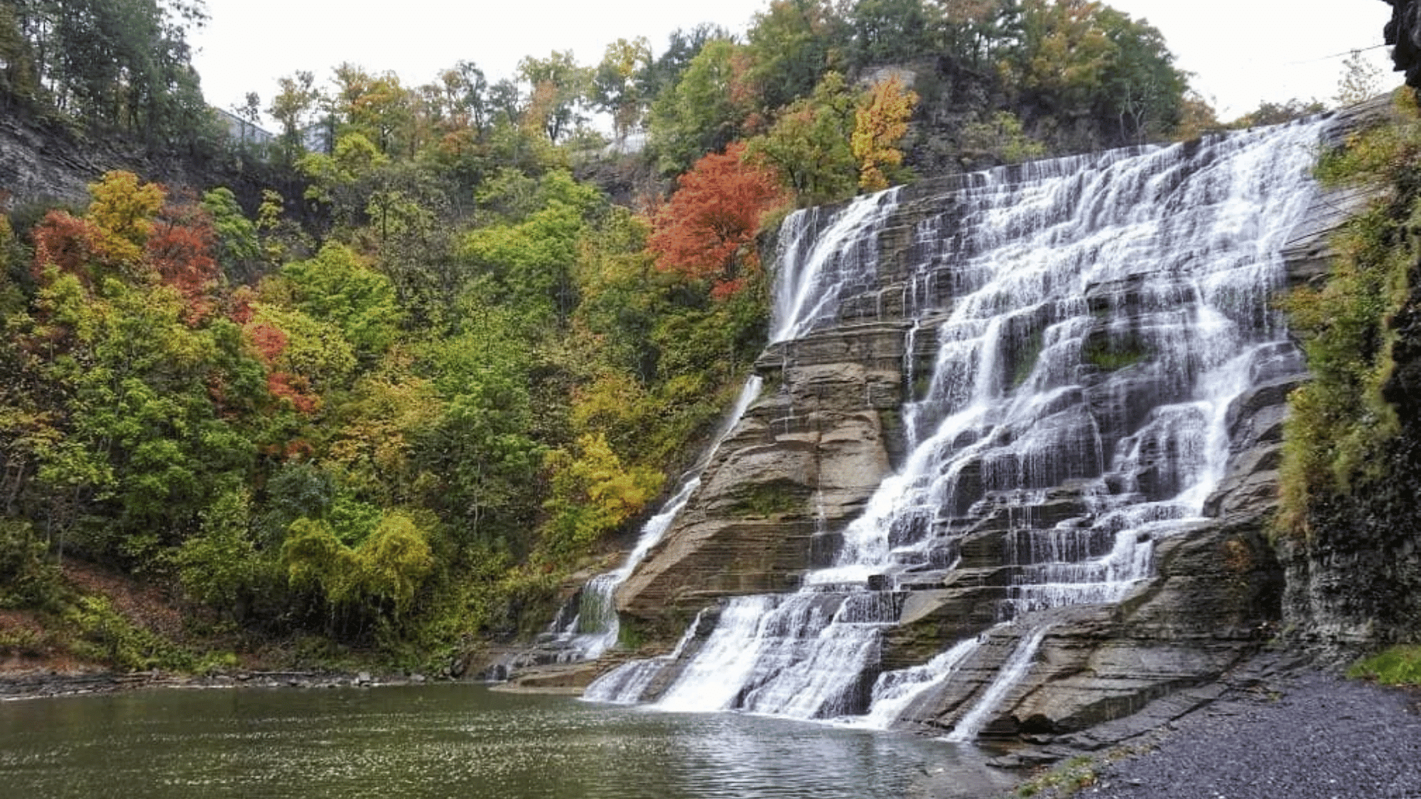 Waterfall in Finger Lakes New York with autumn trees and visitors at scenic overlook