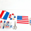 Collection of Memorial Day crafts including flags and art supplies arranged on a table