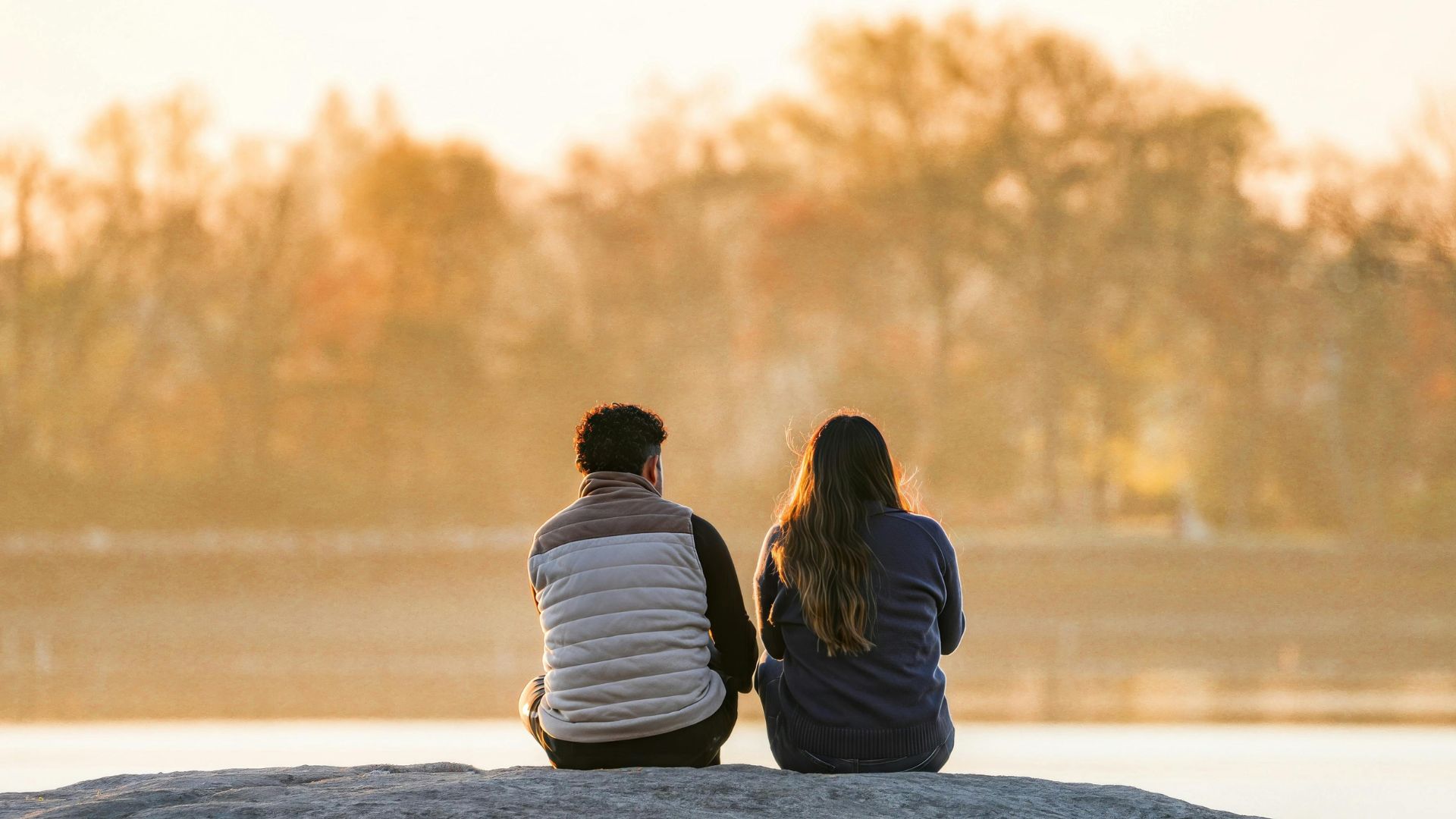 Couple sitting by a lake at sunset, a peaceful idea among things to do on Memorial Day for reflection, relaxation, and honoring the day quietlySpend the Day at the Lake