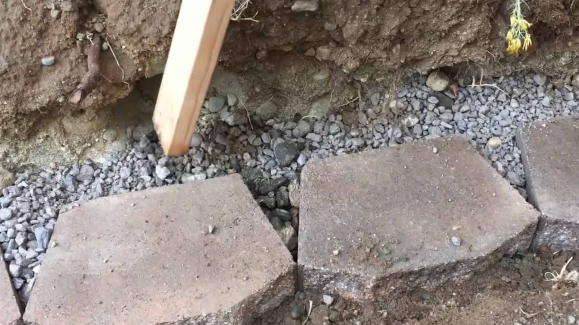 Drainage gravel placed behind retaining wall blocks to allow water flow and reduce pressure buildup