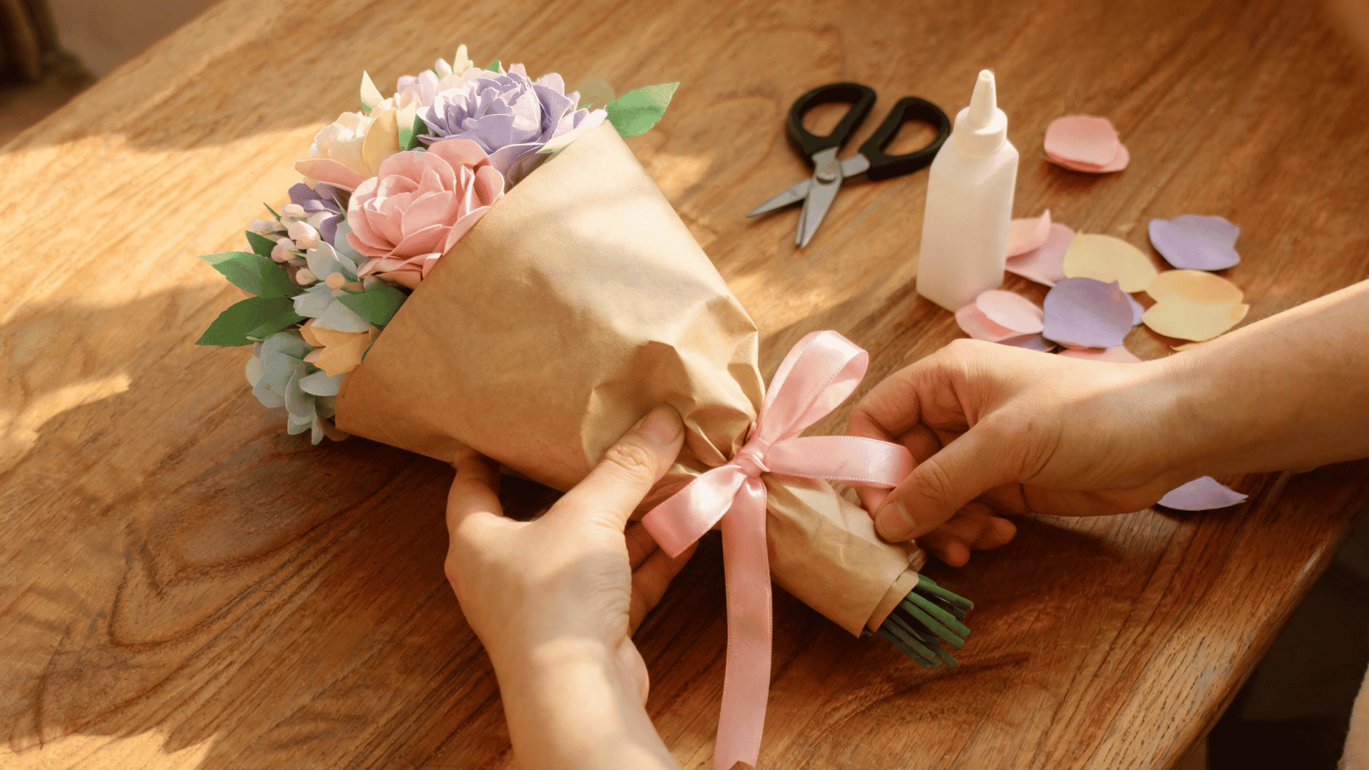 Finished handmade paper flower bouquet wrapped with ribbon on a craft table. (1)