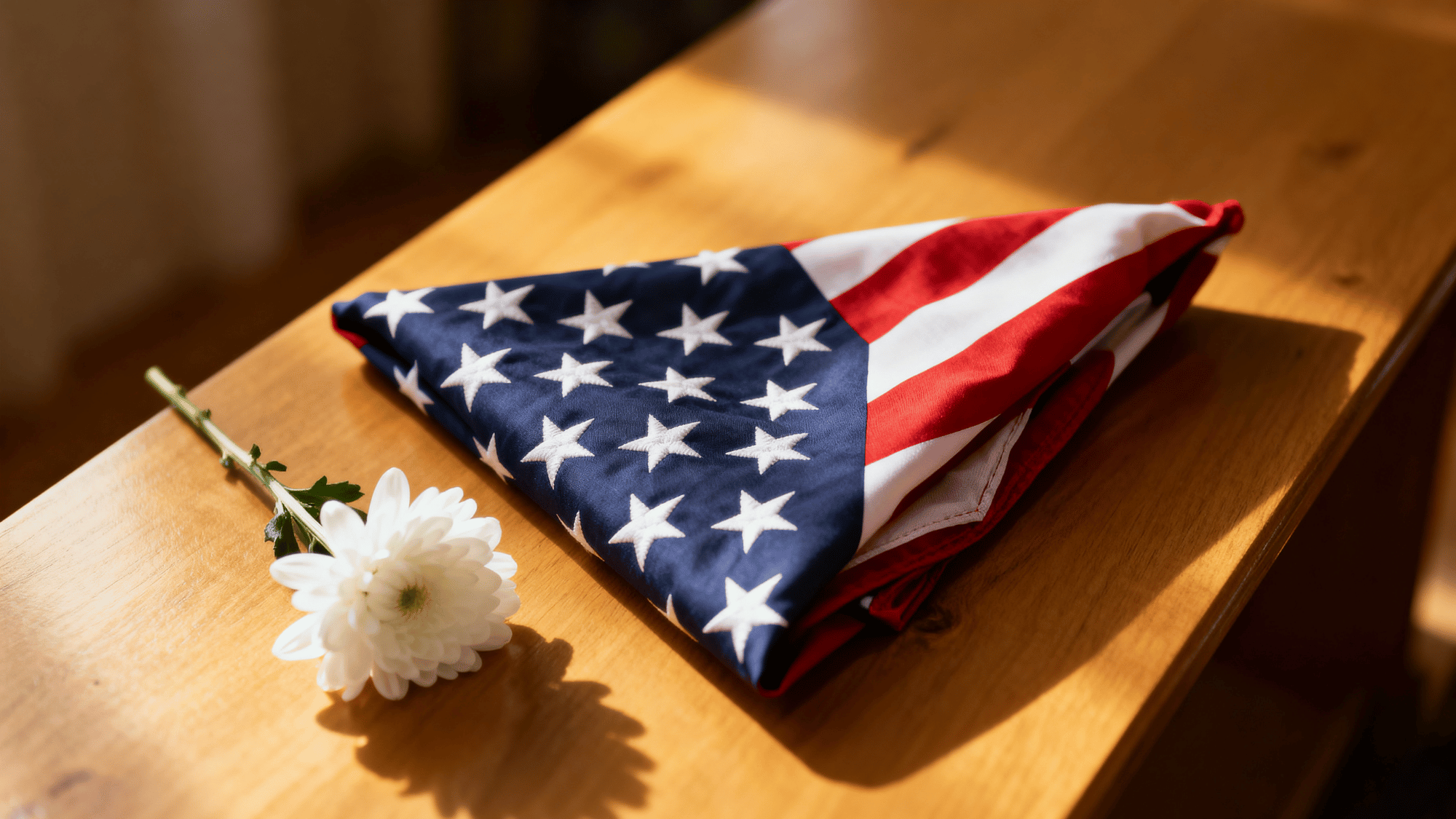 Folded flag with white flower showing remembrance and heartfelt tribute.