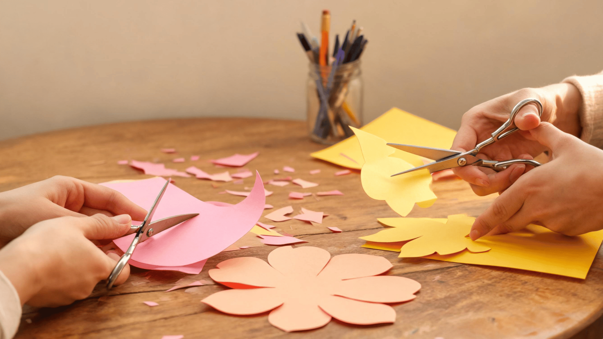 Hands cutting colorful paper petals and leaves for a handmade flower bouquet. (1)