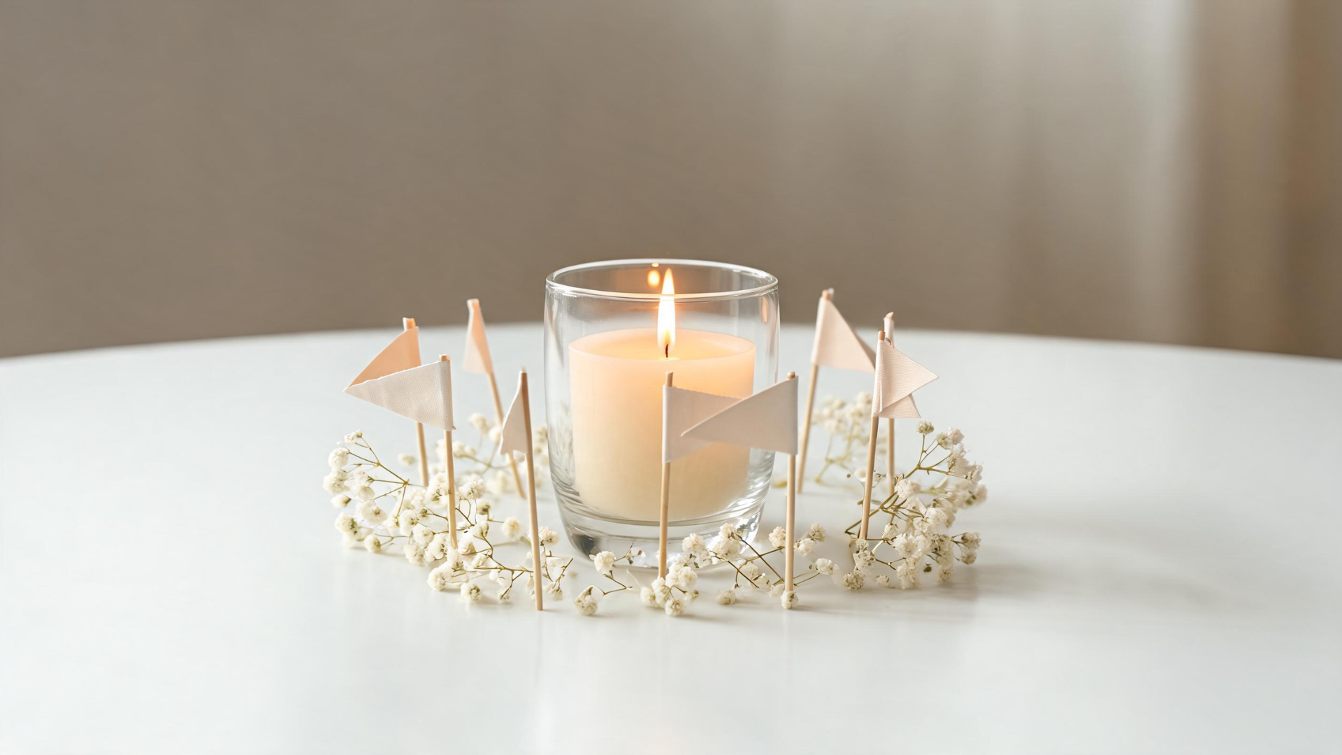 Memorial tribute candle centerpiece with small flags and flowers on a simple table setting