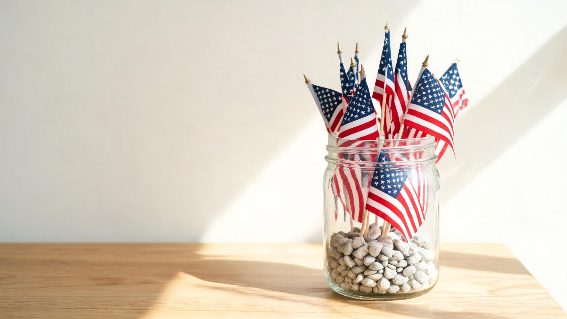 Mini American flags arranged in a jar with pebbles as a simple Memorial Day table centerpiece