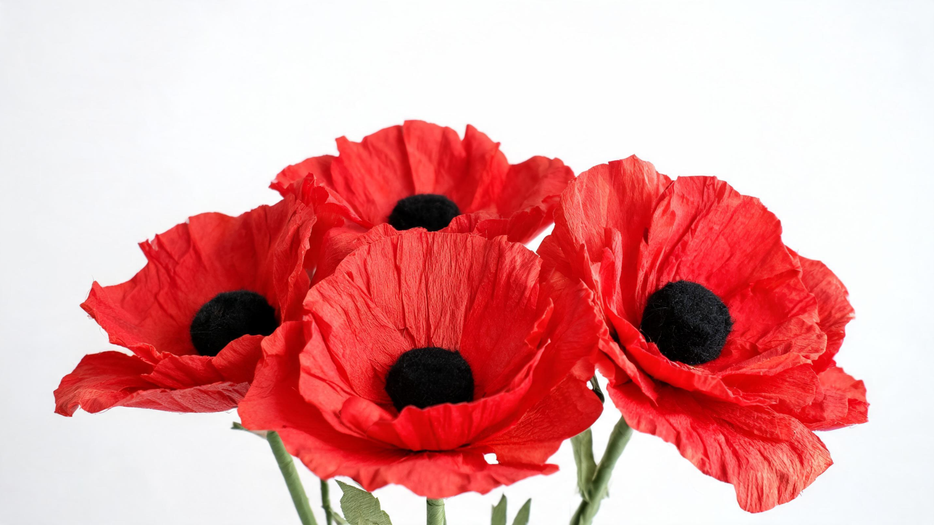 Red paper poppy flowers created as a Memorial Day craft displayed on a clean surface