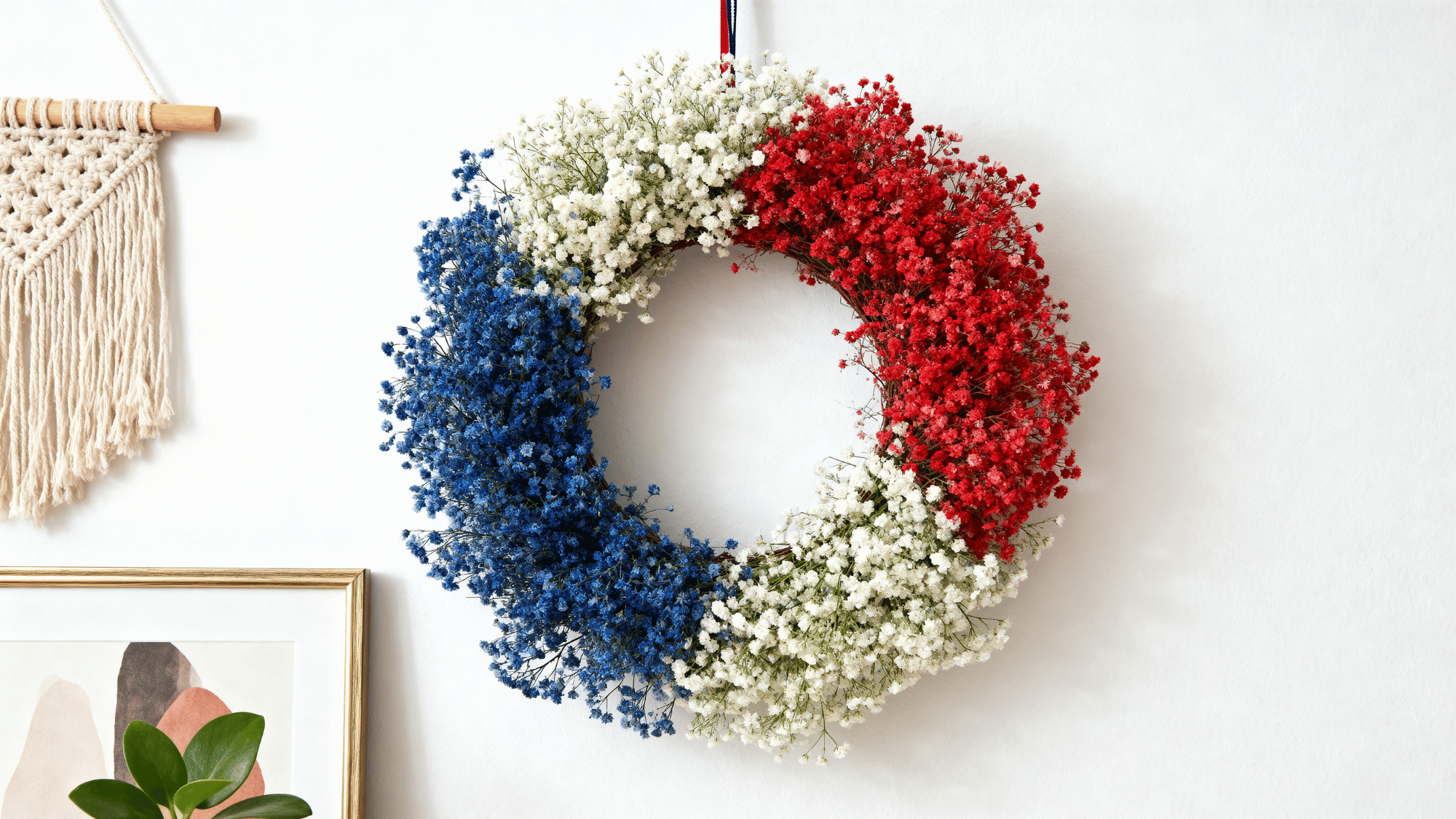 _Red, white, and blue floral wreath hanging on wall with simple home decor background