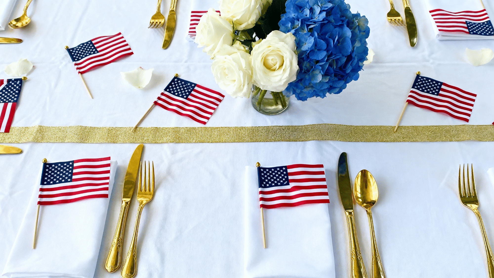 Red white blue and gold Memorial Day table decor with flags and flowers