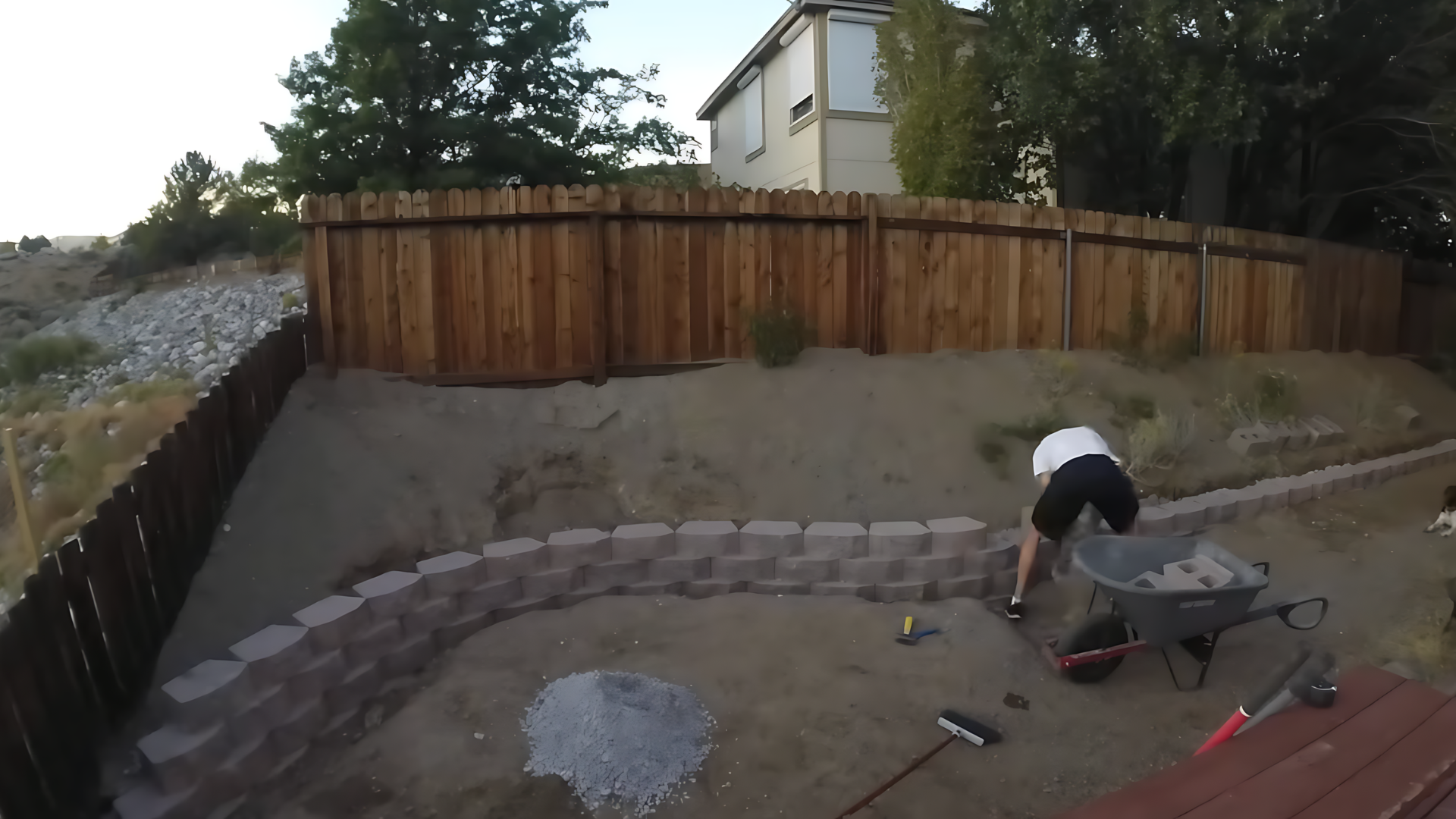 Stacking retaining wall blocks in staggered pattern while building layers for improved strength and support